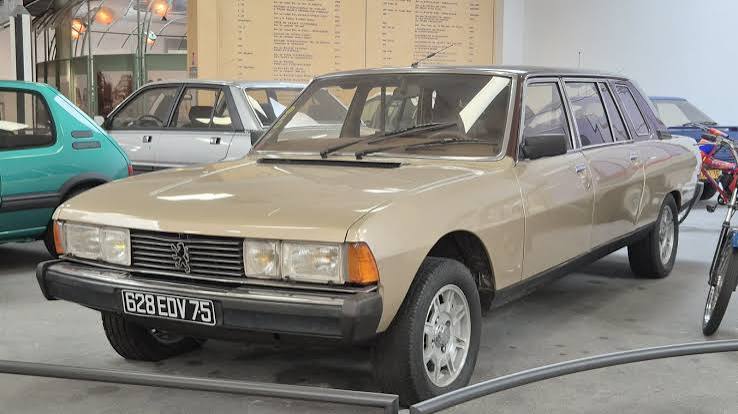 Peugeot 604 Limousine beige à six glaces latérales, exposée dans un hall de musée