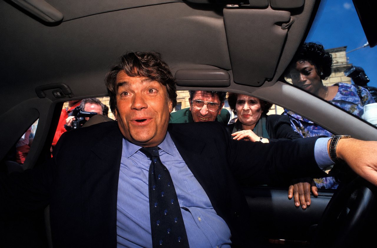 Bernard Tapie dans sa Renault Safrane Biturbo, entouré d'une foule