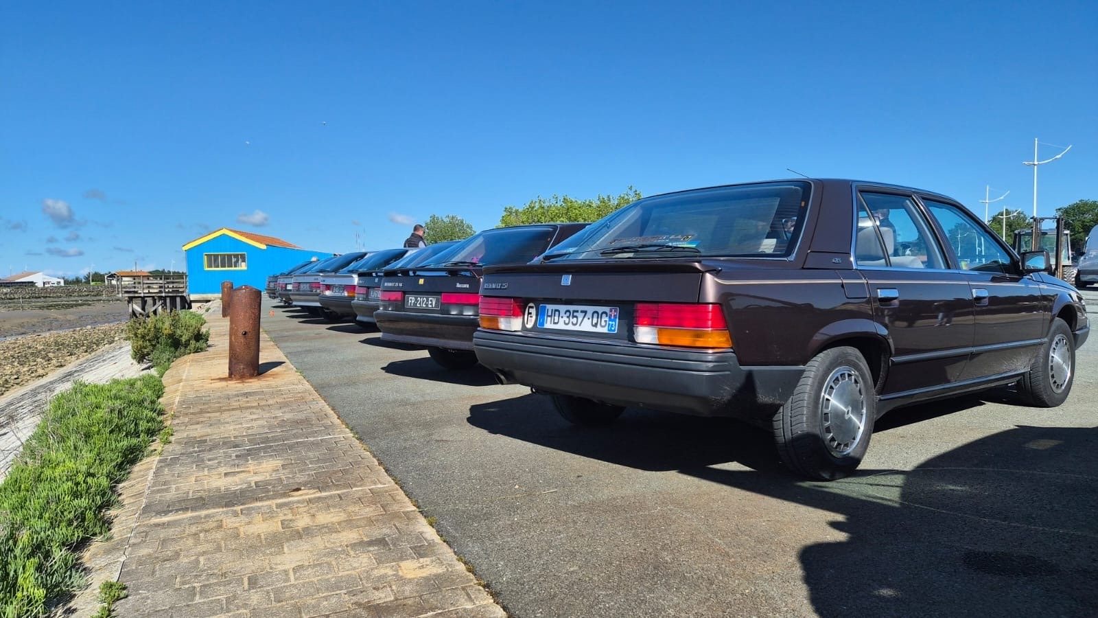 A burgundy Renault 25 parked along a quay