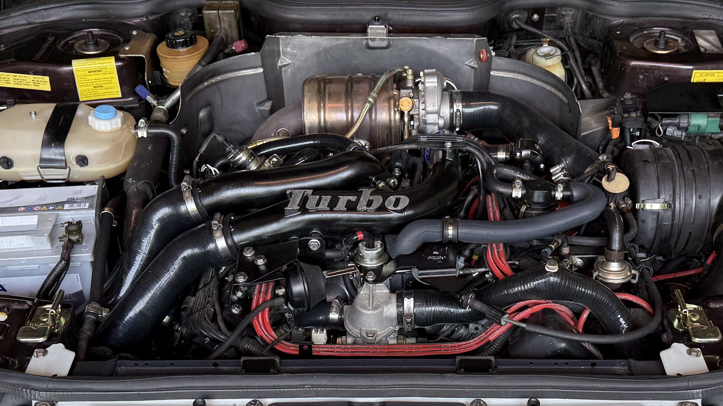 The Z7U 700 PRV V6 in the engine bay of a Renault 25 Baccara V6 Turbo: intake plenum marked « Turbo », turbocharger under its heat shield and air filter box